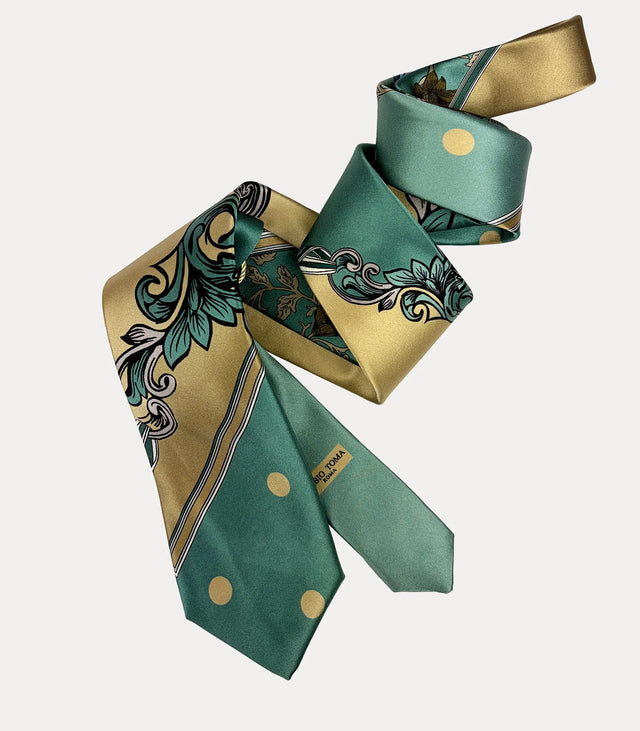 Cravatta in seta verde e oro con pois e volute, disposta a spirale con logo Fabio Toma Roma visibile sul codino.