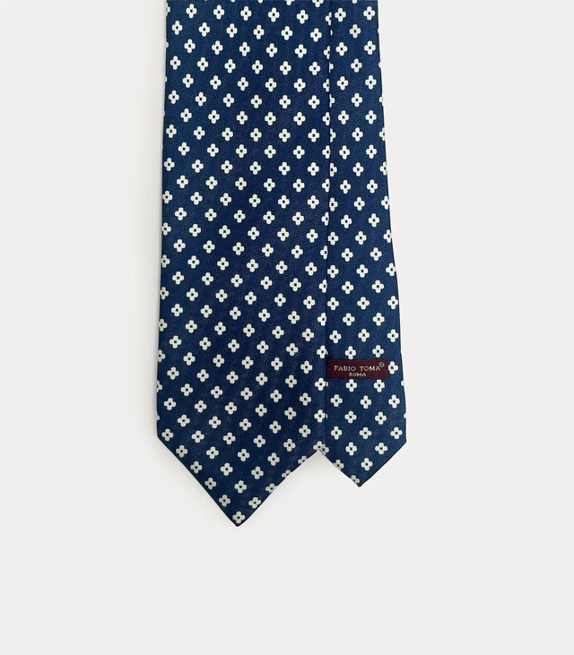 Cravatta Fabio Toma Roma in seta blu navy con micro fiori bianchi, vista frontale del design.