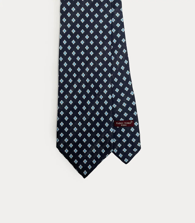 Cravatta Fabio Toma Roma in seta blu navy con micro pattern geometrico azzurro e bianco, vista frontale.