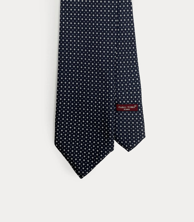 Dettaglio frontale cravatta Fabio Toma Roma in seta blu notte con micro pattern geometrico bianco, manifattura artigianale.