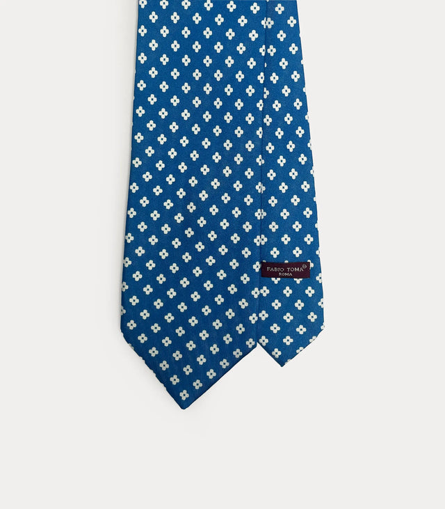 Cravatta Fabio Toma Roma in seta blu con micro pattern floreale bianco e dettaglio del passante.