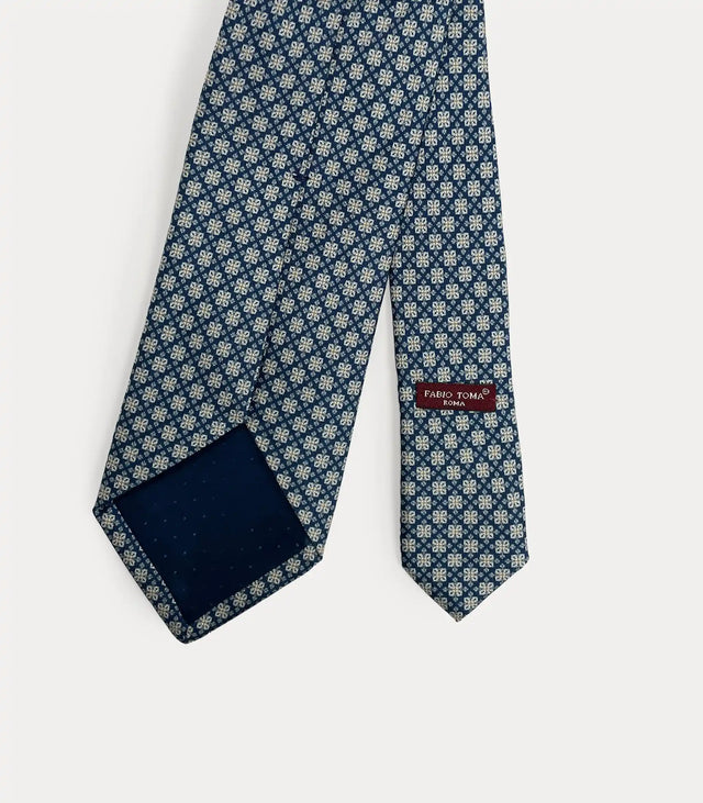 Vista posteriore della cravatta blu in seta che mostra il passante sartoriale, le finiture fatte a mano e l'etichetta del brand.