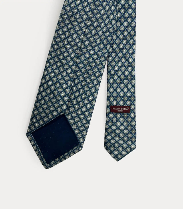 Vista posteriore della cravatta blu in seta che mostra il passante sartoriale, le finiture fatte a mano e l'etichetta del brand.