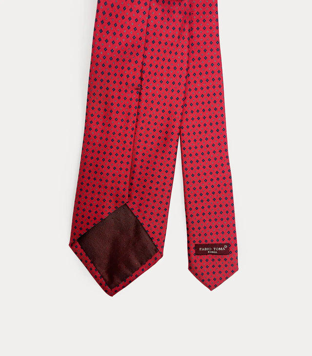 Vista posteriore della cravatta rossa in seta che mostra il passante sartoriale e le rifiniture fatte a mano Made in Italy.