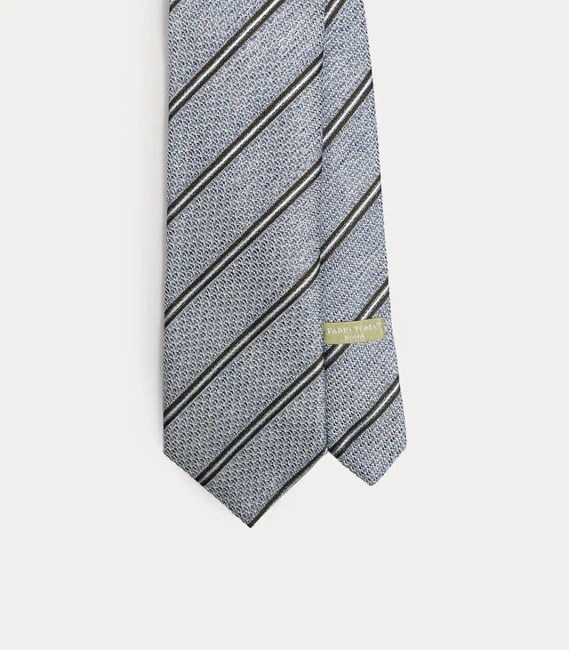 Cravatta Fabio Toma Roma in seta celeste testurizzata con righe diagonali marroni e bianche, dettaglio del pattern e della trama.