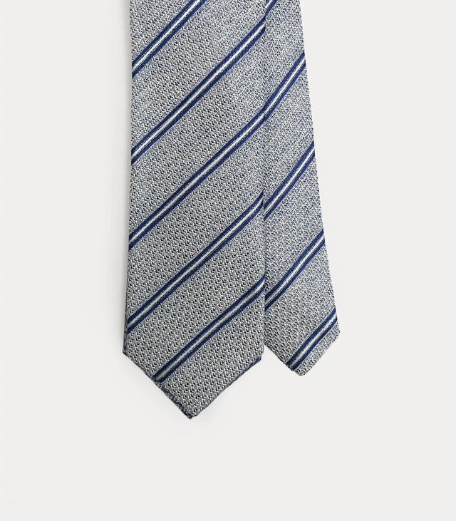 Cravatta Fabio Toma Roma in seta grigia testurizzata con righe diagonali blu e bianche, vista ravvicinata della trama.