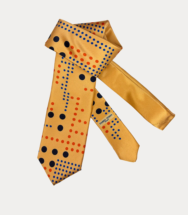 Cravatta giallo oro a pois blu e arancio, ripiegata con codino coordinato e logo Fabio Toma Roma visibile.