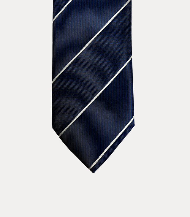Cravatta Fabio Toma in seta blu navy con righe diagonali avorio e bande a spina di pesce.
