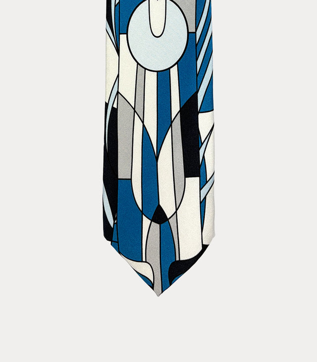 Cravatta Fabio Toma in seta avorio e blu con disegno floreale geometrico e dettagli celesti, grigi e neri.