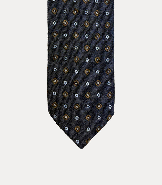 Cravatta Fabio Toma Q815 in 100% lana blu navy con rombi ocra, centri avorio e piccoli cerchi celesti.