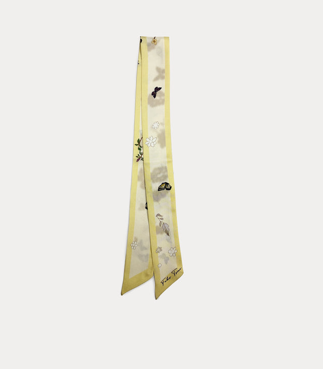 Nastro twilly lungo e sottile, piegato a metà. Presenta bordi di colore giallo pastello, un fondo chiaro e una delicata stampa sparsa con farfalle, fiori stilizzati bianchi e leggere ombreggiature grigio-verdi. Firma Fabio Toma visibile in basso.