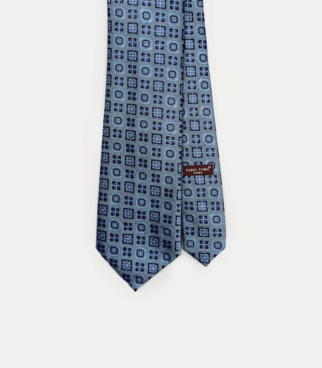 Cravatta azzurra in seta con motivi geometrici blu