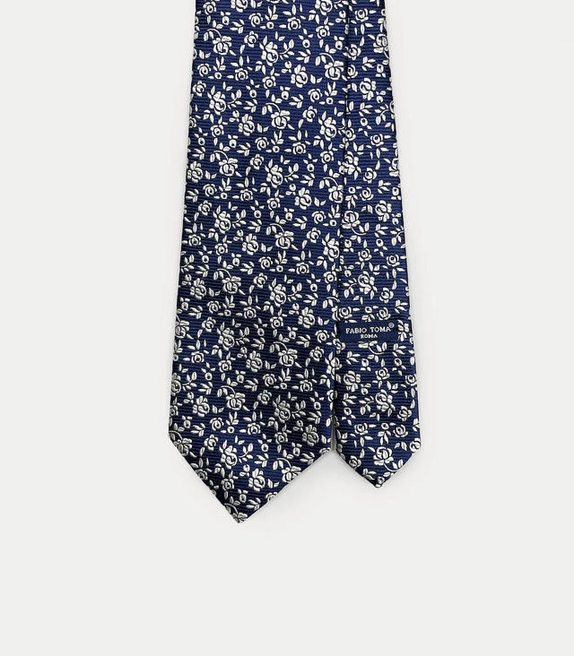 Cravatta blu scuro in seta jacquard con microdisegno floreale bianco