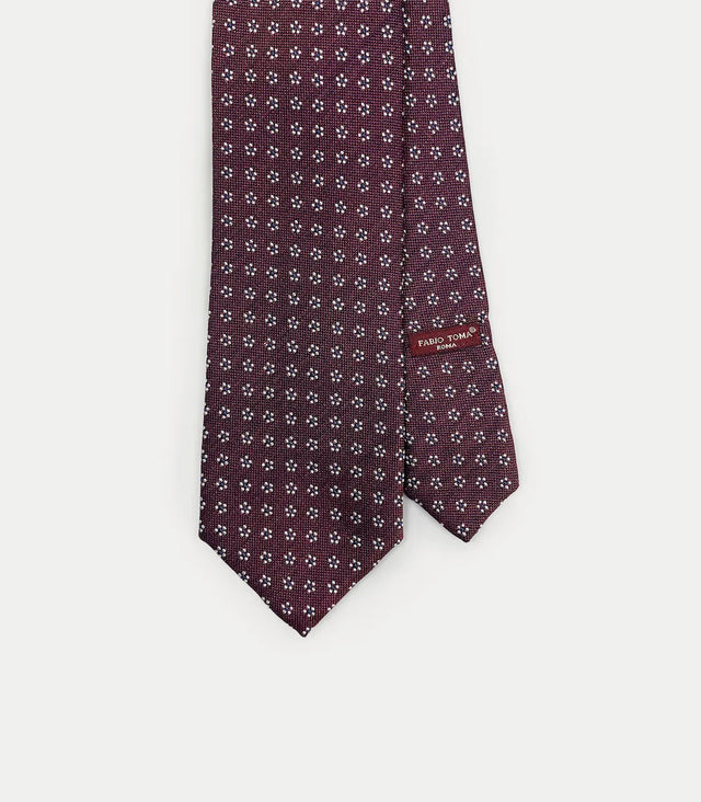 Cravatta bordeaux in seta con motivo a piccoli fiori bianchi e blu