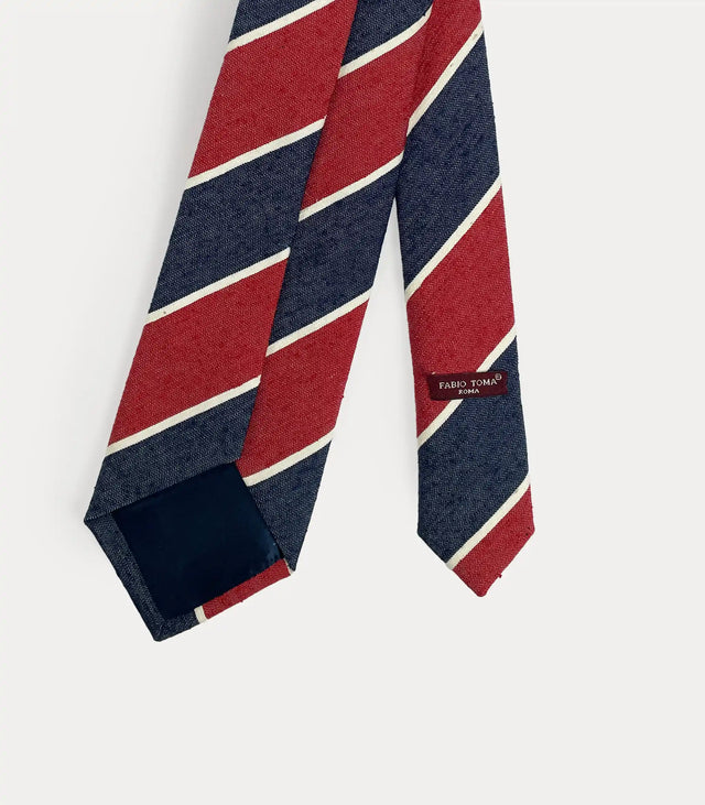 Cravatta regimental in pura seta a righe diagonali rosso e blu navy con profili bianchi fatta a mano in Italia.