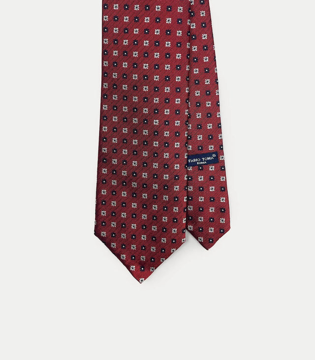 Cravatta rosso mattone in seta con microfantasia bianca e blu