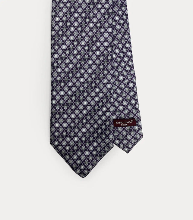 Dettaglio ravvicinato della cravatta Fabio Toma Roma in seta Bordo con micro pattern floreale, vista frontale con etichetta.