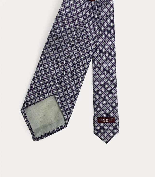 Vista posteriore della cravatta bordo in seta che mostra il passante sartoriale, le finiture fatte a mano e l'etichetta del brand.