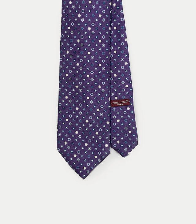 Cravatta viola in seta twill stampata con motivo floreale e stellato